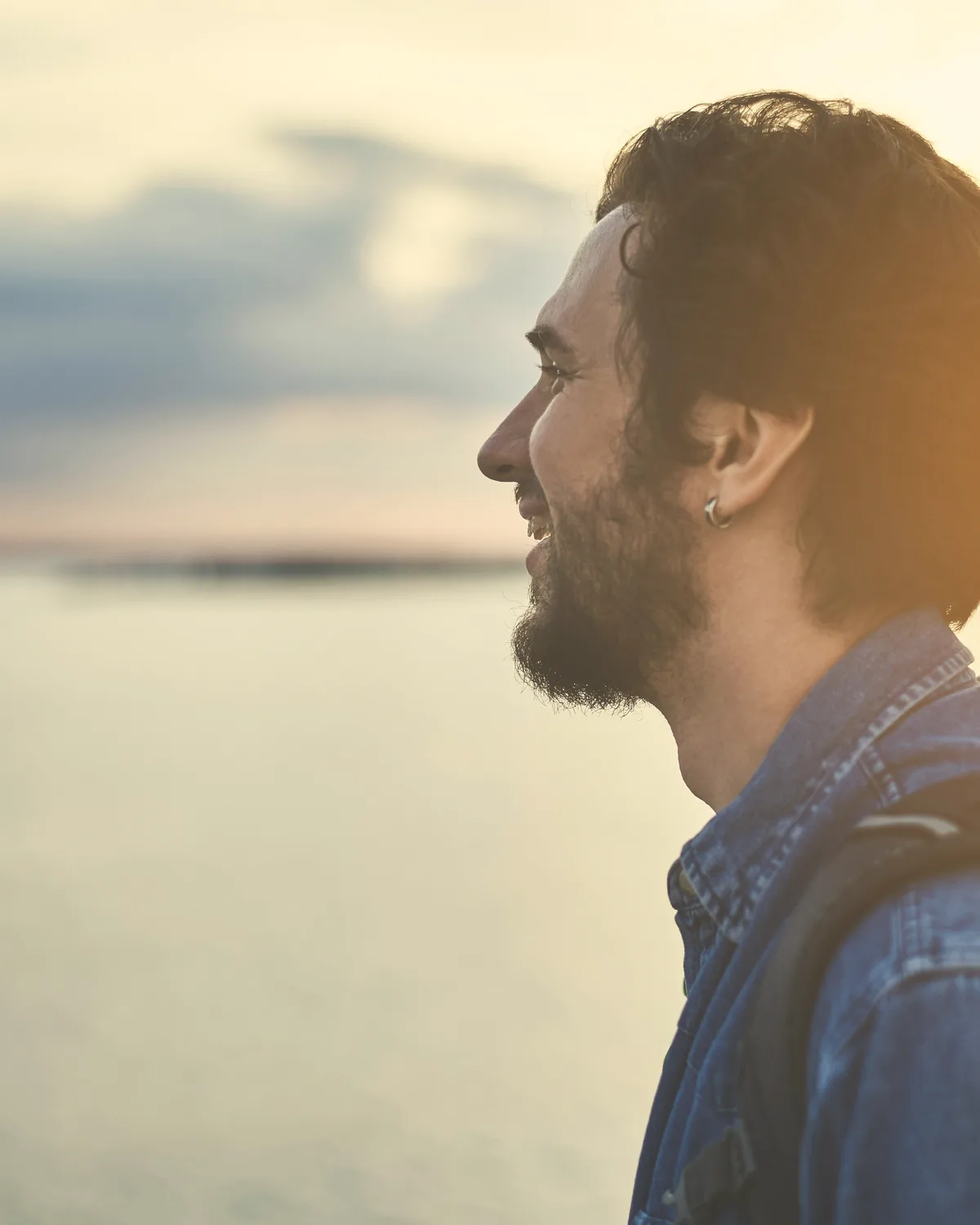 Hombre junto a un lago, de espaldas, mirando al agua